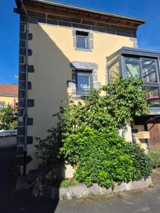 a building with a bush in front of it at Maison cozy dans les Volcans in Sayat