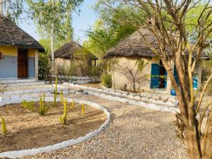 a garden in front of a house with a tree at Les Calaos du Saloum in Sokone