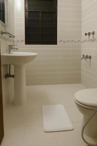 a white bathroom with a sink and a toilet at Luxury Apartment in Gulshan 2 Next to 5 Star Renaissance Hotel in Gulshan 1 +16 photos