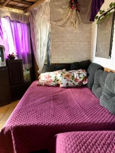 1 dormitorio con 1 cama con edredón morado en Recanto Privativo Suíte Brisa de Araruama - Região dos Lagos, en Araruama