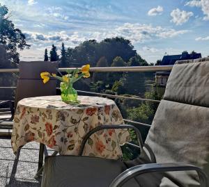 a table with a vase of flowers on a balcony at Schöne, helle, ruhige Wohnung und Wellness Sauna in Irbersdorf