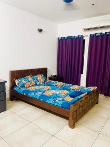 a bed in a room with purple curtains at Luxury Apartment in Gulshan 2 Next to 5 Star Renaissance Hotel in Gulshan 1 +16 photos