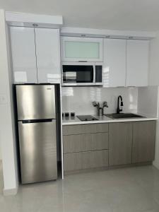 a kitchen with a stainless steel refrigerator and microwave at JC Apartment - One bedroom in Toa Baja