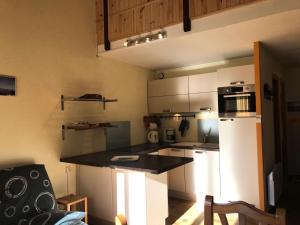 a kitchen with a refrigerator and a counter top at Résidence Les Campanules - Très jolie trois pièces situé proche centre MAE-3484 in Corrençon-en-Vercors