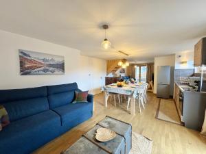 a living room with a blue couch and a table at AO Duplex 82 m2 in Vars