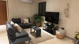 a living room with a couch and a flat screen tv at Casa Mia in Chuburná