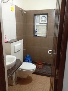 ein Badezimmer mit Toilette und Waschbecken und einem Fenster in der Unterkunft Heritage Exotica 2BHK Apartment service apartments in goa in Arpora