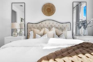 a bedroom with a large white bed with a large headboard at The Entertainers Duplex- Perfect for Gathering 16 in Houston