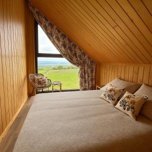 a bedroom with a bed and a large window at Domki Baby Jagi in Krajno Pierwsze