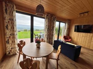 a living room with a table and a couch at Domki Baby Jagi in Krajno Pierwsze