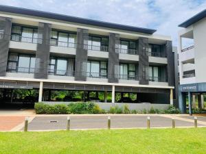 a large building with a lawn in front of it at Zimbali Lakes Boulevard Suites 145 in Ballito +7 photos
