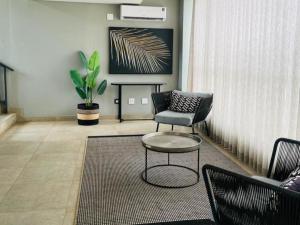 a living room with a chair and a table at Zimbali Lakes Boulevard Suites 145 in Ballito