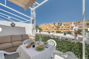 a white table and chairs on a balcony with a couch at Sun Garden in Adeje