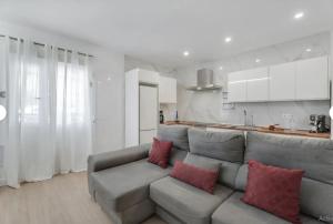 a living room with a gray couch with red pillows at Sun Garden in Adeje