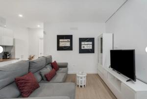 a living room with a gray couch and a flat screen tv at Sun Garden in Adeje