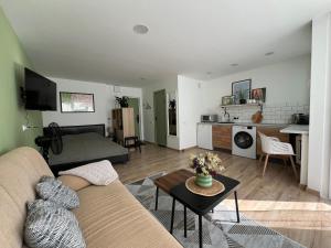 a living room with a couch and a table at DvaroStudio jaukus butas centre self-check-in in Šiauliai