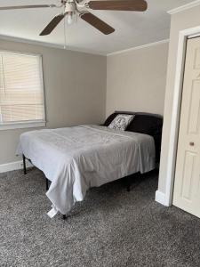 a bedroom with a bed and a ceiling fan at Casa Minimal Cottage Pet Friendly with Fenced Yard in Raeford