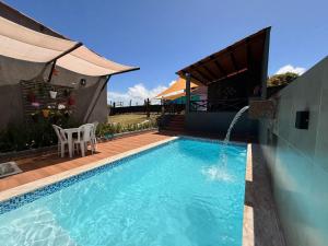 a swimming pool with a water fountain in a house at Suíte Porto das Dunas in Salvador