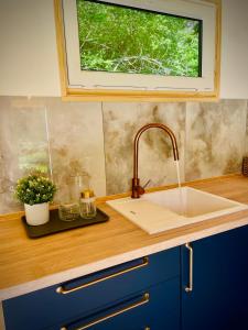 a kitchen counter with a sink and a window at Krušnoglamp - Tinyhouse u Řeky in Sadov +21 photos