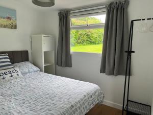 a bedroom with a bed and a window at 23 Sea Valley, Quiet Chalet at Bideford Bay holiday park in Bideford +37 photos