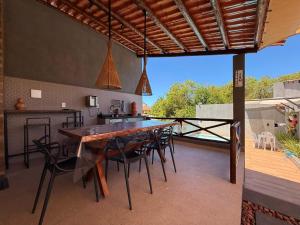 an outdoor kitchen with a large wooden table and chairs at Suíte Porto das Dunas in Salvador