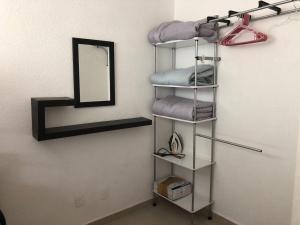 a towel rack with towels and a mirror in a room at Marina Diamante - Ilse C in Acapulco +11 photos