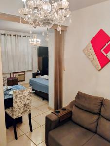 a living room with a couch and a table at Flat aconchegante e tranquilo in Campos dos Goytacazes