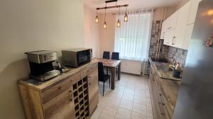 a kitchen with a counter with a microwave on top of it at Oliva Apartman in Salgótarján