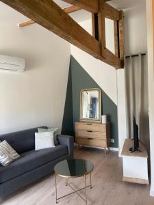a living room with a blue couch and a mirror at Entre bourg et plage, climatisé, grande terrasse, WIFI, parking gratuit, linge et ménage compris in Mimizan