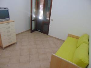 a living room with a green couch and a tv at Il Moro della Molpa in Palinuro