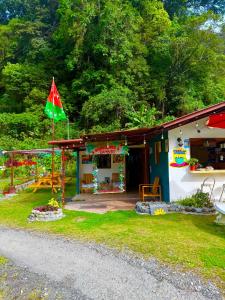 a small house with a flag in the yard at Bambito´s Café & Hostel in Cerro Punta +15 photos