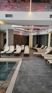 una habitación con sillas y una piscina en un edificio en Residence Hill A036 Apartment, en Kopaonik