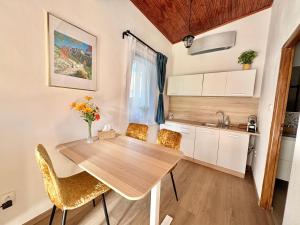 a kitchen and dining room with a wooden table and chairs at Little park house with car charger in Stupava