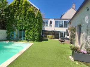 a yard with a swimming pool next to a house at Maison ALMA Piscine -Baby Foot - Cheminée- Jacuzzi in Vantoux