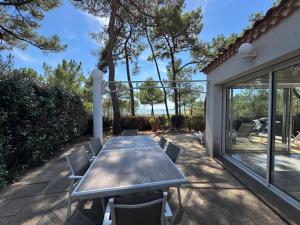 a wooden table and chairs on a patio at Maison La tranche-sur-mer Vue mer in La Tranche-sur-Mer