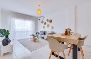 a white living room with a table and chairs at Brisa Algarvia 2 in Faro