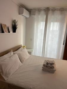 Un dormitorio con una cama con toallas. en Cozy apartment 5 min to the sea and airport, en Isola Sacra