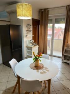 cocina con mesa blanca y sillas blancas en Cozy apartment 5 min to the sea and airport, en Isola Sacra