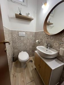 Un baño con inodoro, lavabo y espejo. en Cozy apartment 5 min to the sea and airport, en Isola Sacra 30 fotos más