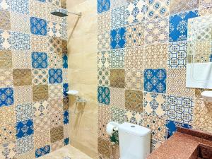 a bathroom with a toilet and a tiled wall at Bab Al Shams Palace in Luxor +115 photos