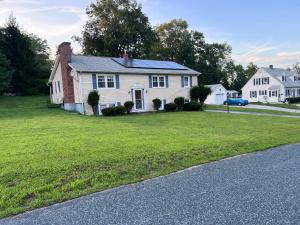 Una casa blanca con un patio de césped y una calle. en 7 Delaney Avenue Dudley MA, en Dudley