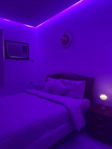 タブークにあるشقة السيف خلف مجمع الغرويの紫色のベッドルーム(ベッド1台、ランプ付)