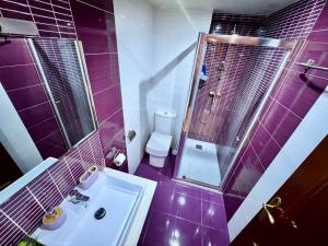 Un baño morado con lavabo e inodoro. en Apartsalou Oasis, en Salou 21 fotos más