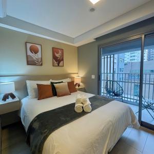 a bedroom with a large bed with shoes on it at Studios Prime Pivô Match - Jardins in Sao Paulo +45 photos