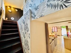 a hallway with a staircase with blue and white wallpaper at Gîtes Montvaltin - Duplex 65 m2, 2 chambres in Le Breuil