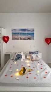 a bed with red hearts and candles on it at Pousada Martanha in Porto Belo