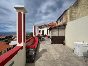 un balcone con una panchina rossa su un edificio di Pôr do Sol a Estreito da Calheta