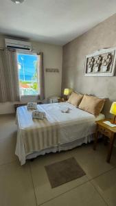a bedroom with a large bed and a window at Pousada Tortugas in Guarujá