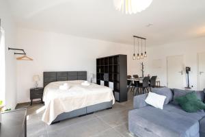 a bedroom with a bed and a couch at Lux Apts Deluxe Apartment-Zentral-Messe-Küche in Cologne