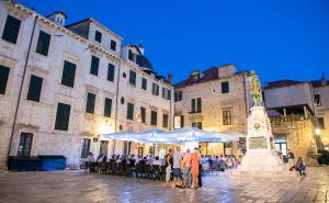 a group of people sitting under umbrellas in a courtyard at Clouds Boutique Guesthouse in Dubrovnik